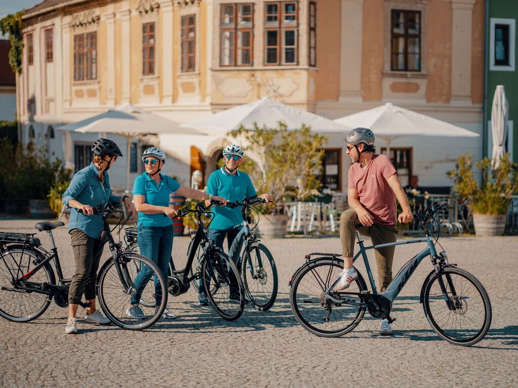 Radfahrergruppe pausiert auf Stadtplatz